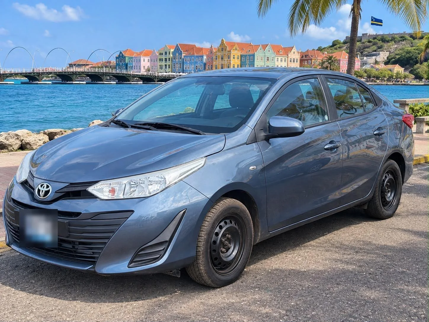 Blue-grey Toyota Yaris sedan, front three-quarter view