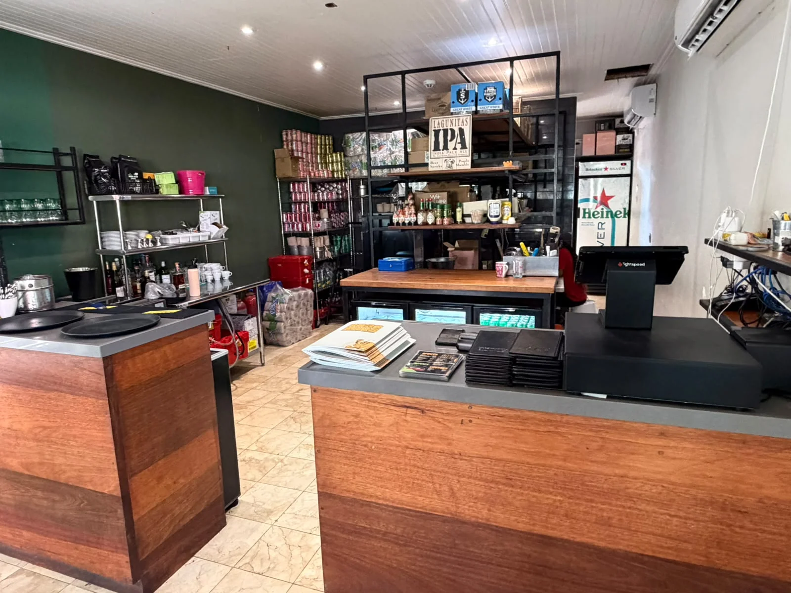 Service counter inside BRGR Haus with a point-of-sale terminal, coffee equipment and drink storage shelves.